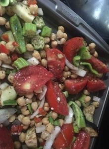 Skillet of roasted vegetables with okra, tomatoes, onions, and beans