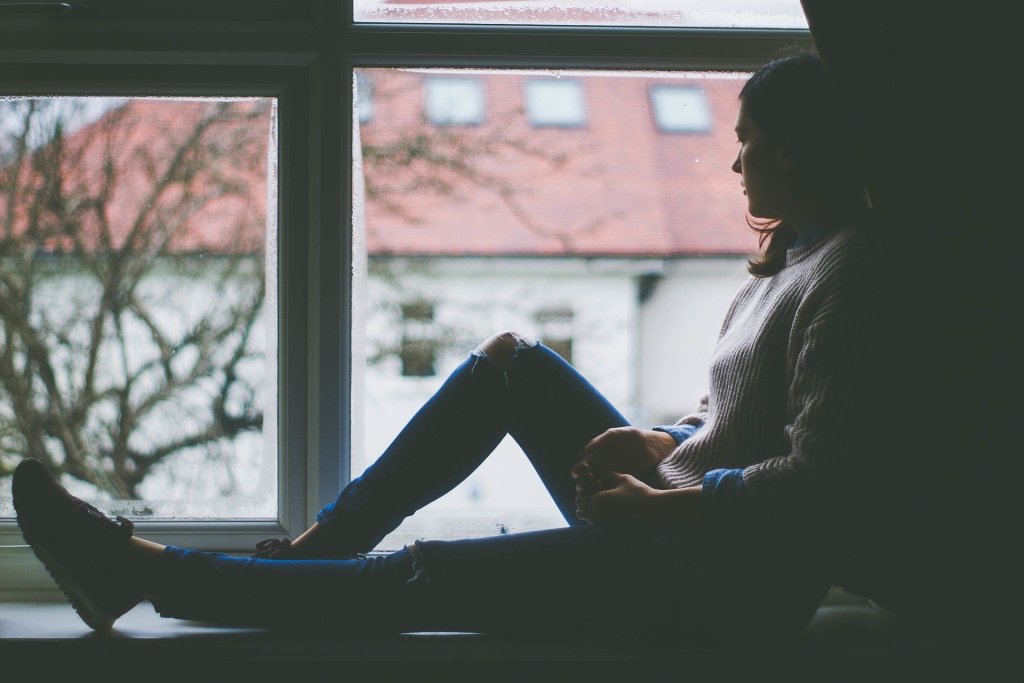 Young woman sitting looking out window