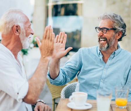 two men having coffee and giving each other a high five